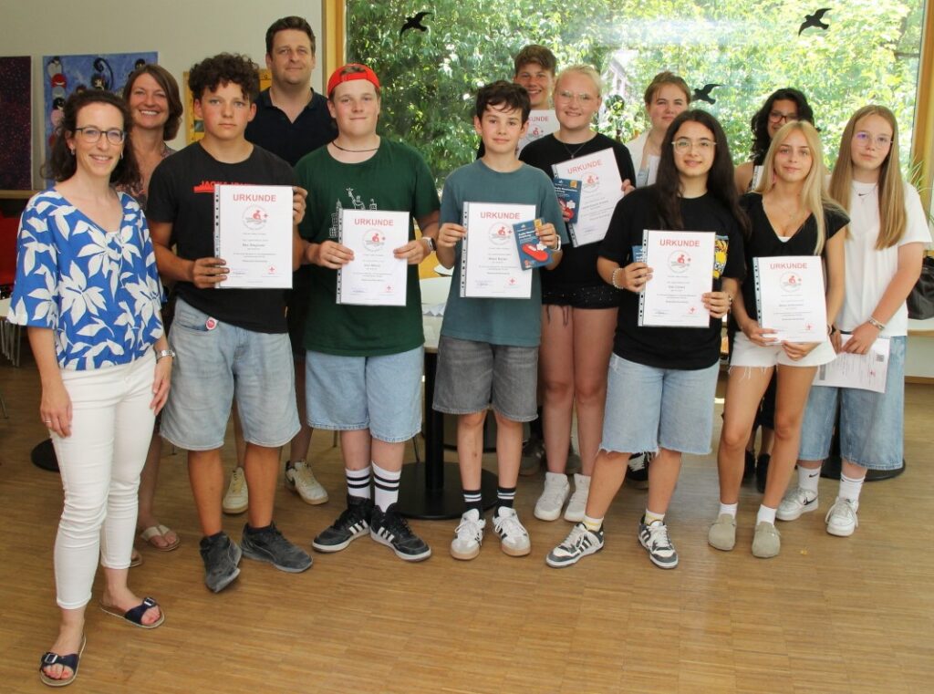 Die Schulsanis präsentieren ihre Urkunden.
